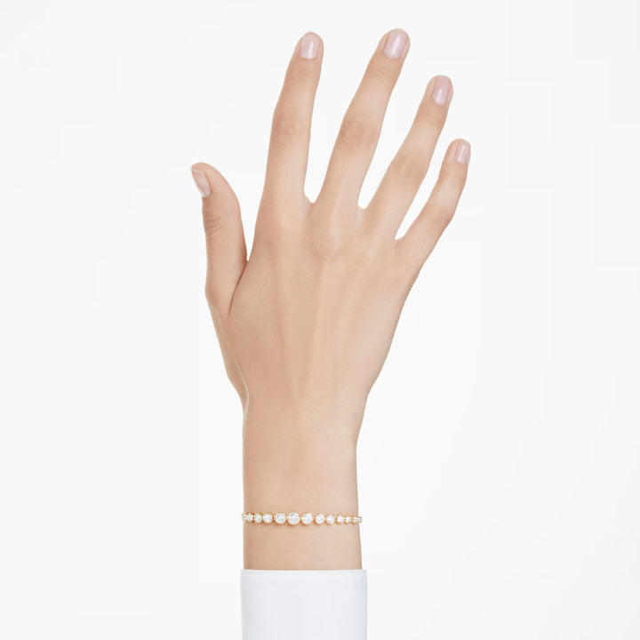 Niche Jewellery Swarovski Imber tennis bracelet with round white crystals on a gold-tone chain worn on a wrist.