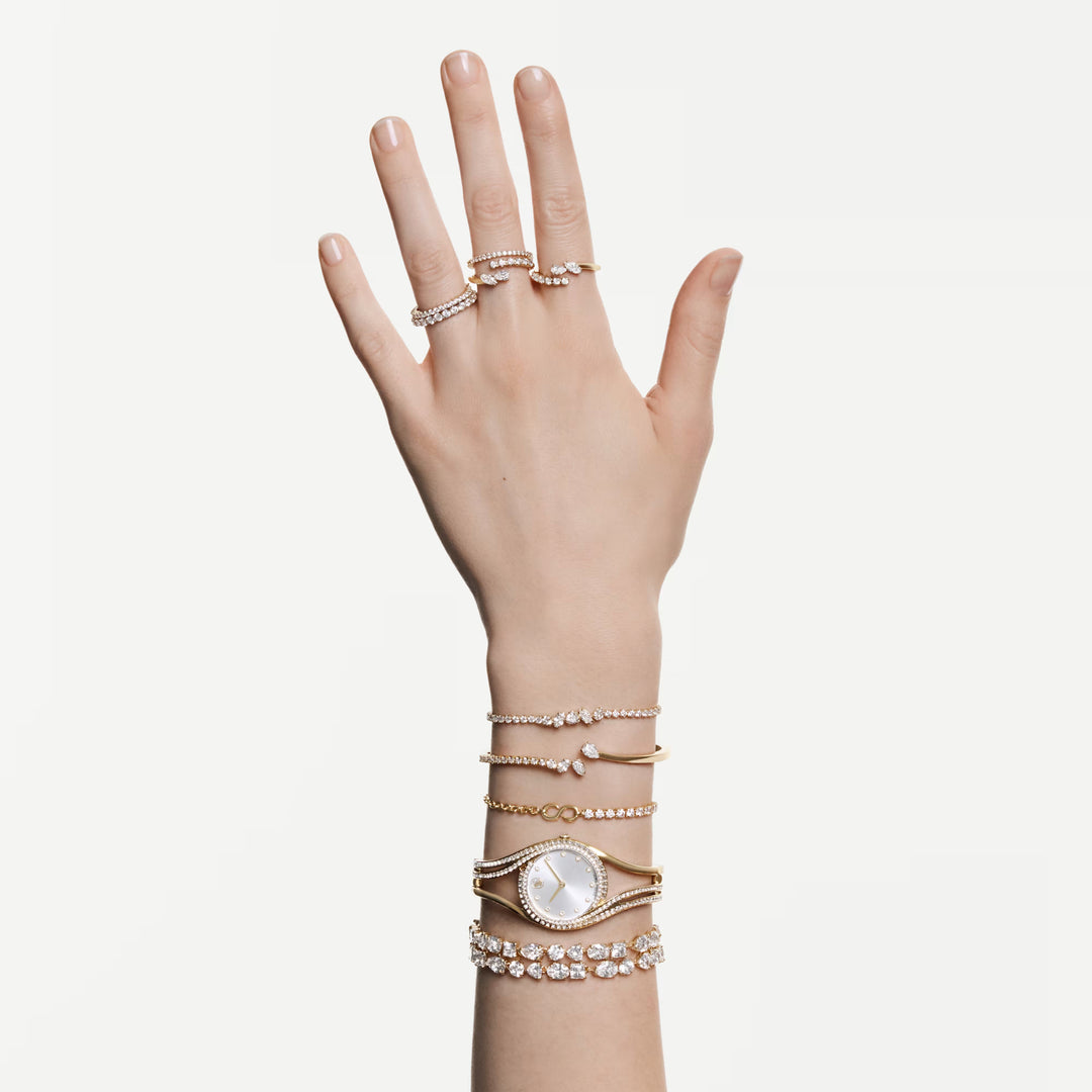 Niche Jewellery Swarovski Mesmera bangle featuring mixed-cut white zirconia stones set in an 18k gold finish band.