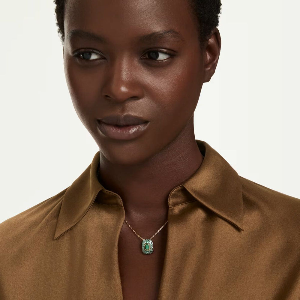 Niche Jewellery Swarovski Sublima pendant featuring a green octagon-cut crystal on an 18K gold-finished chain.