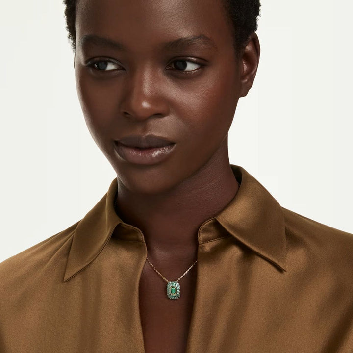 Niche Jewellery Swarovski Sublima pendant featuring a green octagon-cut crystal on an 18K gold-finished chain.