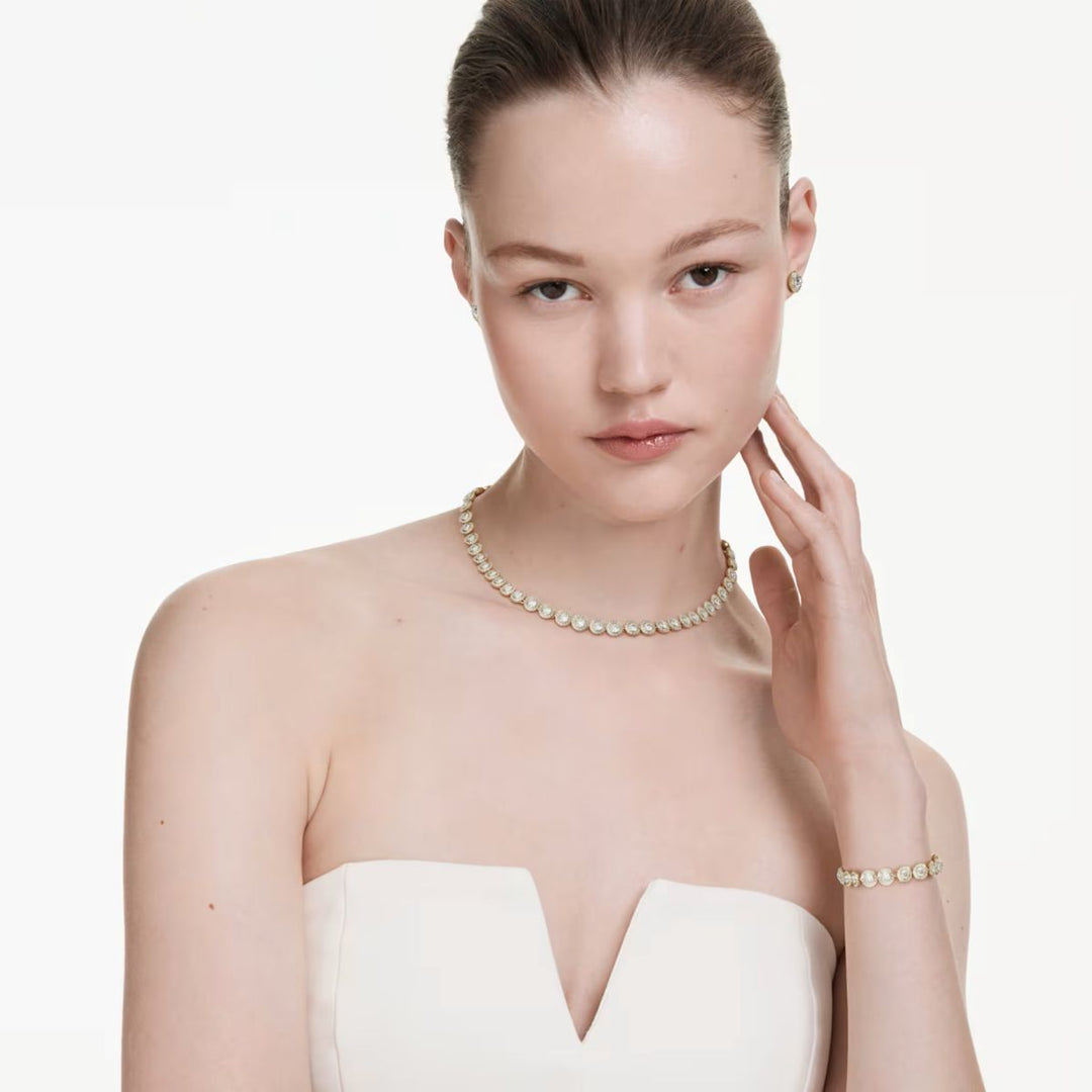 Niche Jewellery Swarovski Una Angelic set featuring a gold-tone necklace, bracelet, and earrings with white crystals.