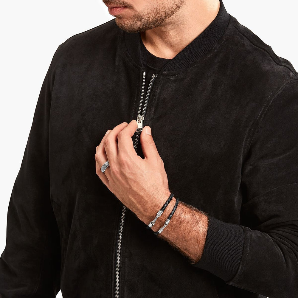 Man wearing a braided black leather Thomas Sabo bracelet with a blackened silver clasp from Niche Jewellery.