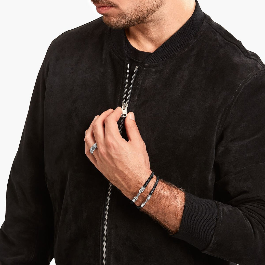 Man wearing a braided black leather Thomas Sabo bracelet with a blackened silver clasp from Niche Jewellery.