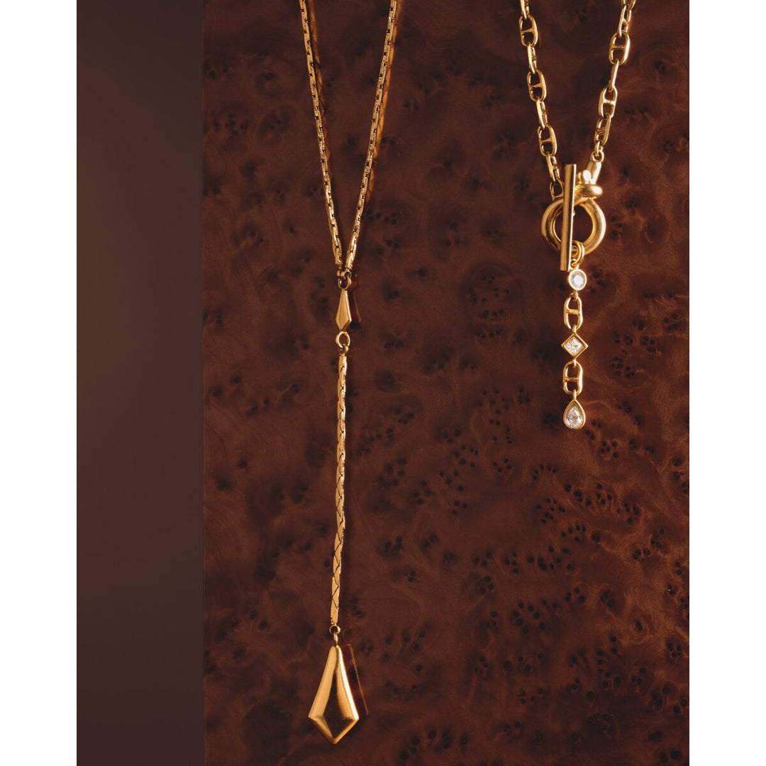 Niche Jewellery Katie Loxton waterproof gold necklaces with sparkling pendant and toggle clasp on dark wood background