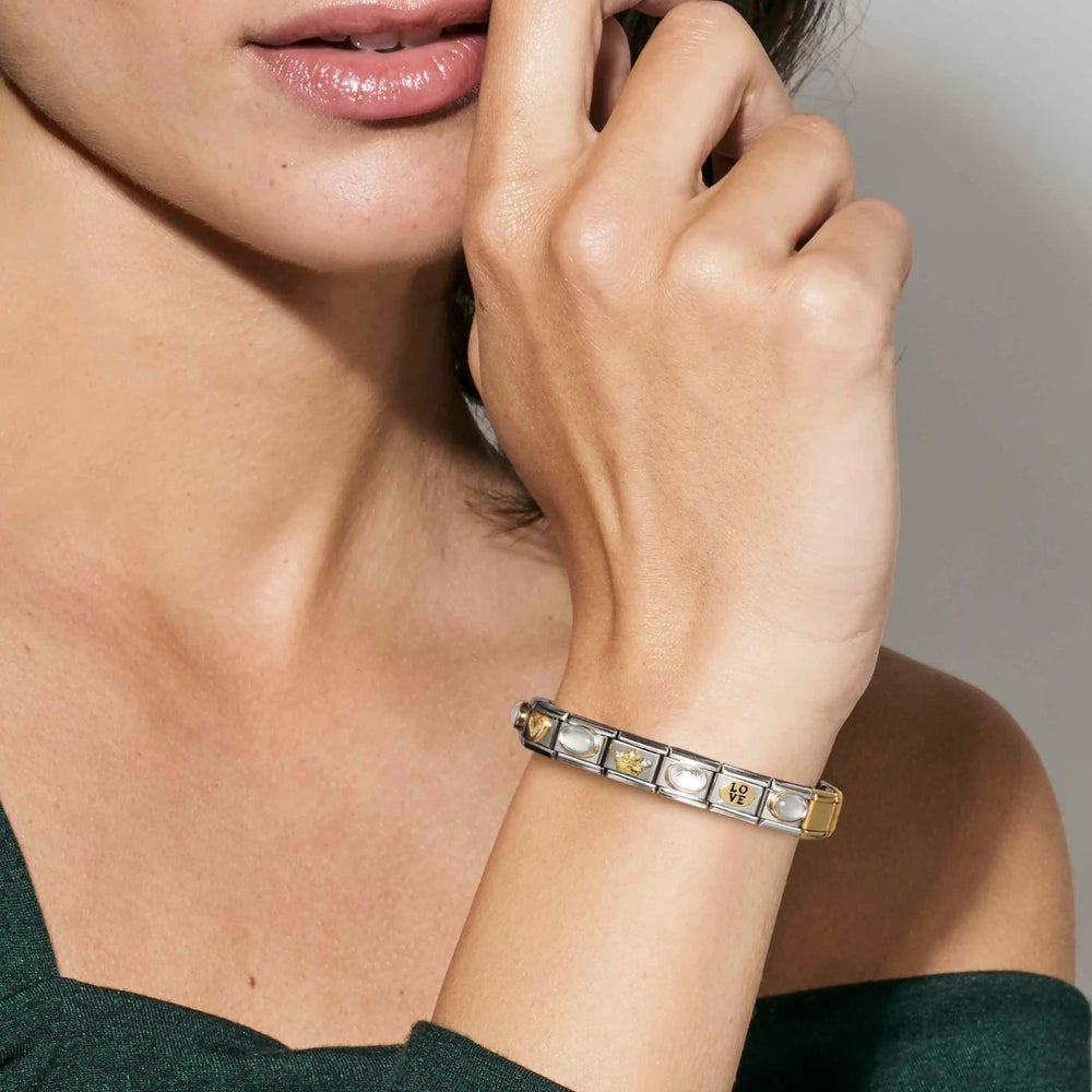 Niche Jewellery Nomination bracelet with gold heart charm, "LOVE" charm, and sunray bezel charms on stainless steel.