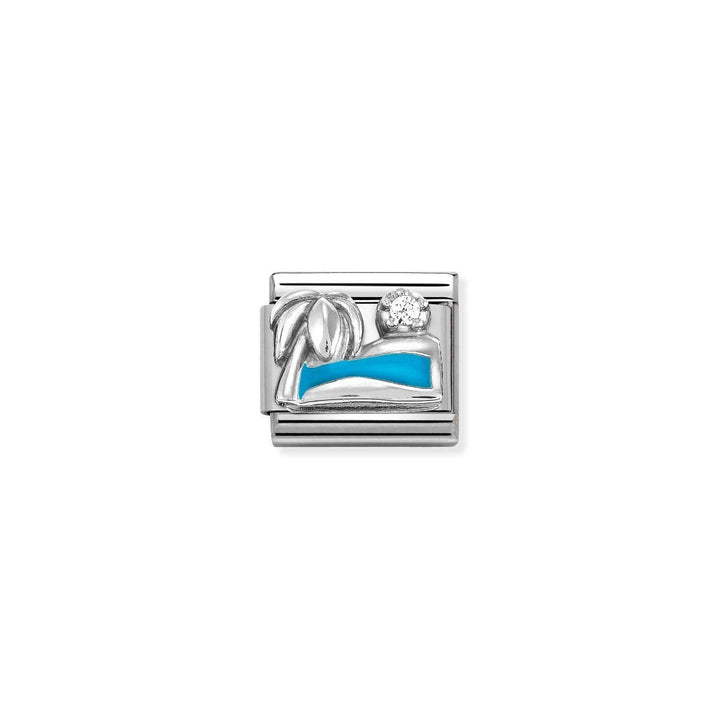 Niche Jewellery silver charm with a palm tree, blue sea enamel, and a sparkling zirconia, evoking a holiday.
