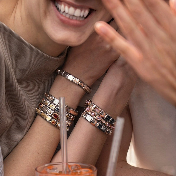 Niche Jewellery Nomination charm with pink faceted zirconia set in 18k gold and stainless steel on a bracelet.